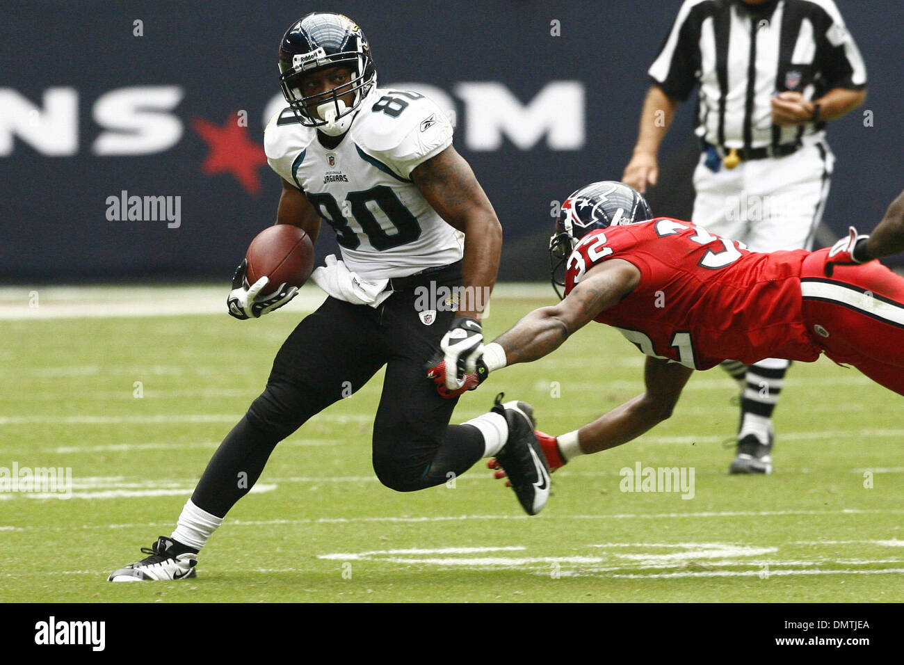 Mike Thomas (#80) of the Jacksonville Jaguars evades a diving tackle by Fred  Bennett (#32) of the Houston Texans. The Jaguars defeated the Texans 31-24  at Reliant Stadium in Houston TX. (Credit