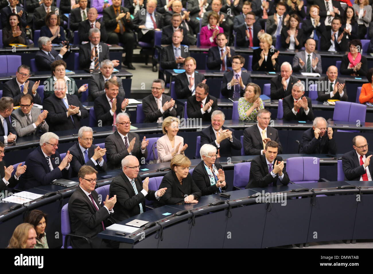 Berlin, Germany. 17th Dec, 2013. German Chancellor Angela Merkel (CDU, 1st Row, 3rd L) sits between the chairman of the CDU/CSU parliamentary group leader Volker Kauder and CSU regional faction leader Gerda Hasselfeldt at the German 'Bundestag' parliament in Berlin, Germany, 17 December 2013. Merkel was voted in for the third time as the country's head of government on 17 December, following a vote by parliamentarians officially returning her to the position. The event marks the beginning of the third so-called grand coalition in Germany's post-war history. © dpa picture alliance/Alamy Live Ne Stock Photo