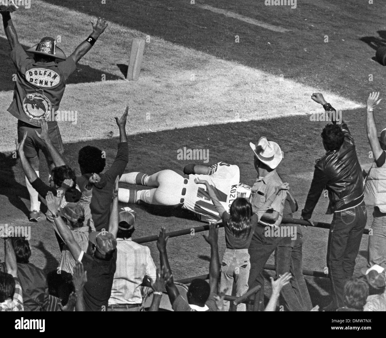 Dec 06, 1981 - Miami, FL, USA - KOZLOWSKI on ground after making touch down. DENNIS (DENNY) SYM aka 'Dolfan Denny' cheers on. DOLFAN DENNY cheers him on. For 34 years Denny Sym cheered the Miami Dolphins. (Credit Image: © Joe Rimkus/Miami News/Palm Beach Post/ZUMA Press) RESTRICTIONS: USA Tabloid RIGHTS OUT! Stock Photo