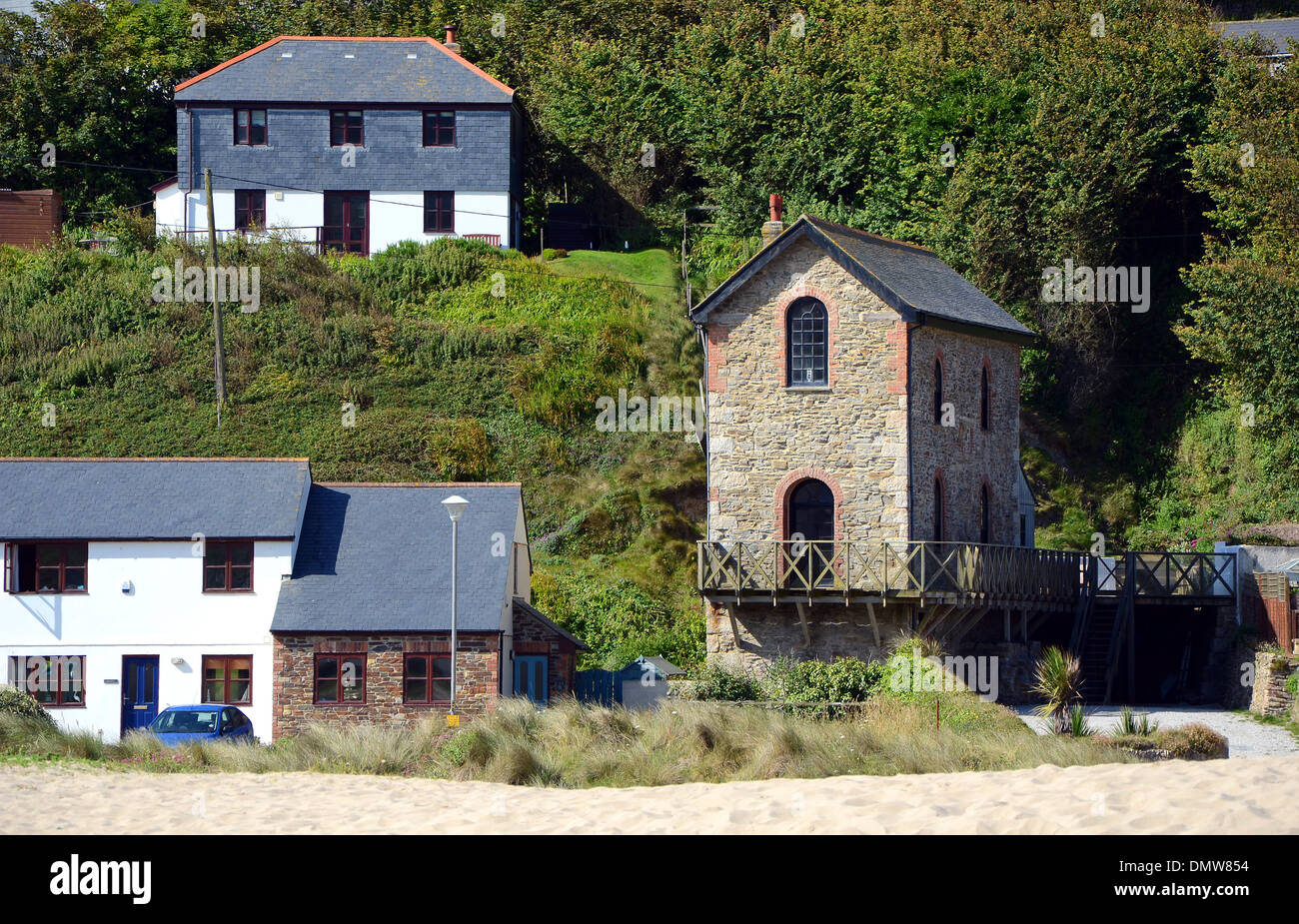 A restored engine house from a former tin mine sits beside new homes at