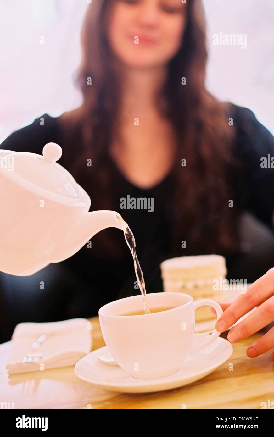A woman pouring a cup of tea Stock Photo