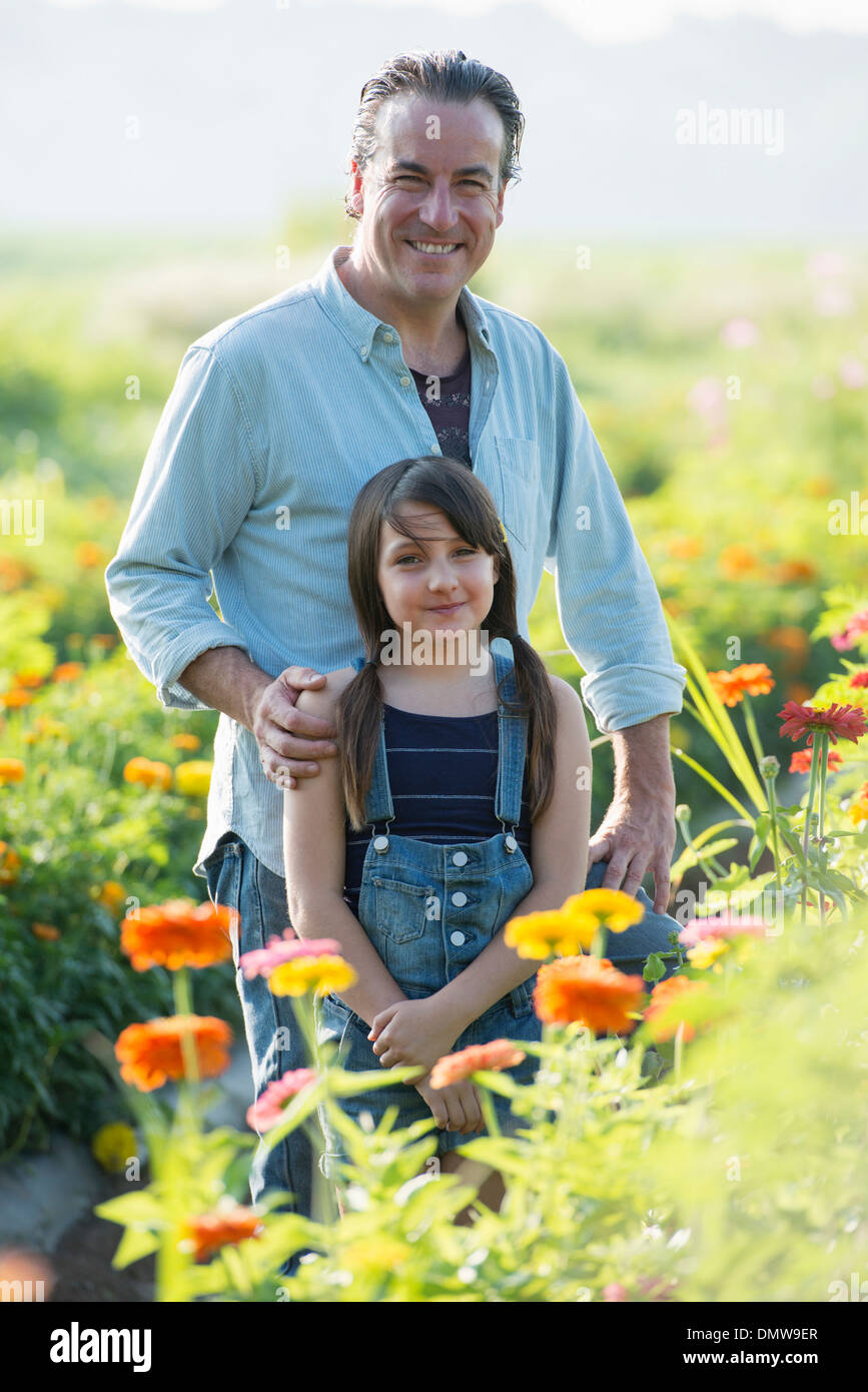 Summer on an organic farm. A man and a girl in a field of flowers. Stock Photo
