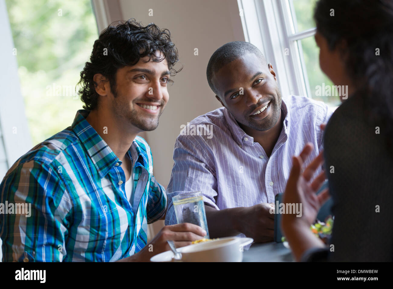 Three people seated at a table. Stock Photo
