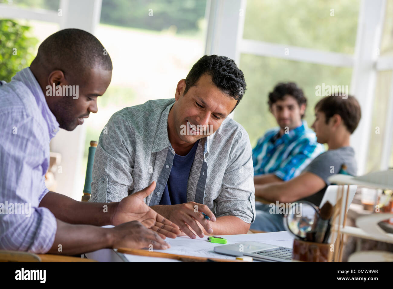 Two men seated working toger. Stock Photo