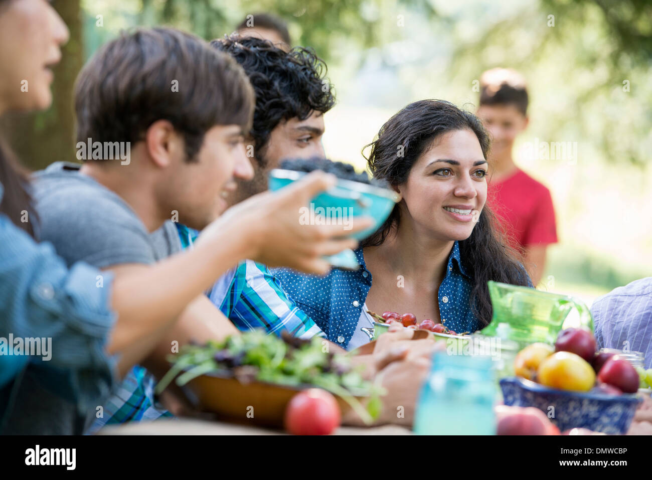 Adults and children around a table at a party in a garden. Stock Photo