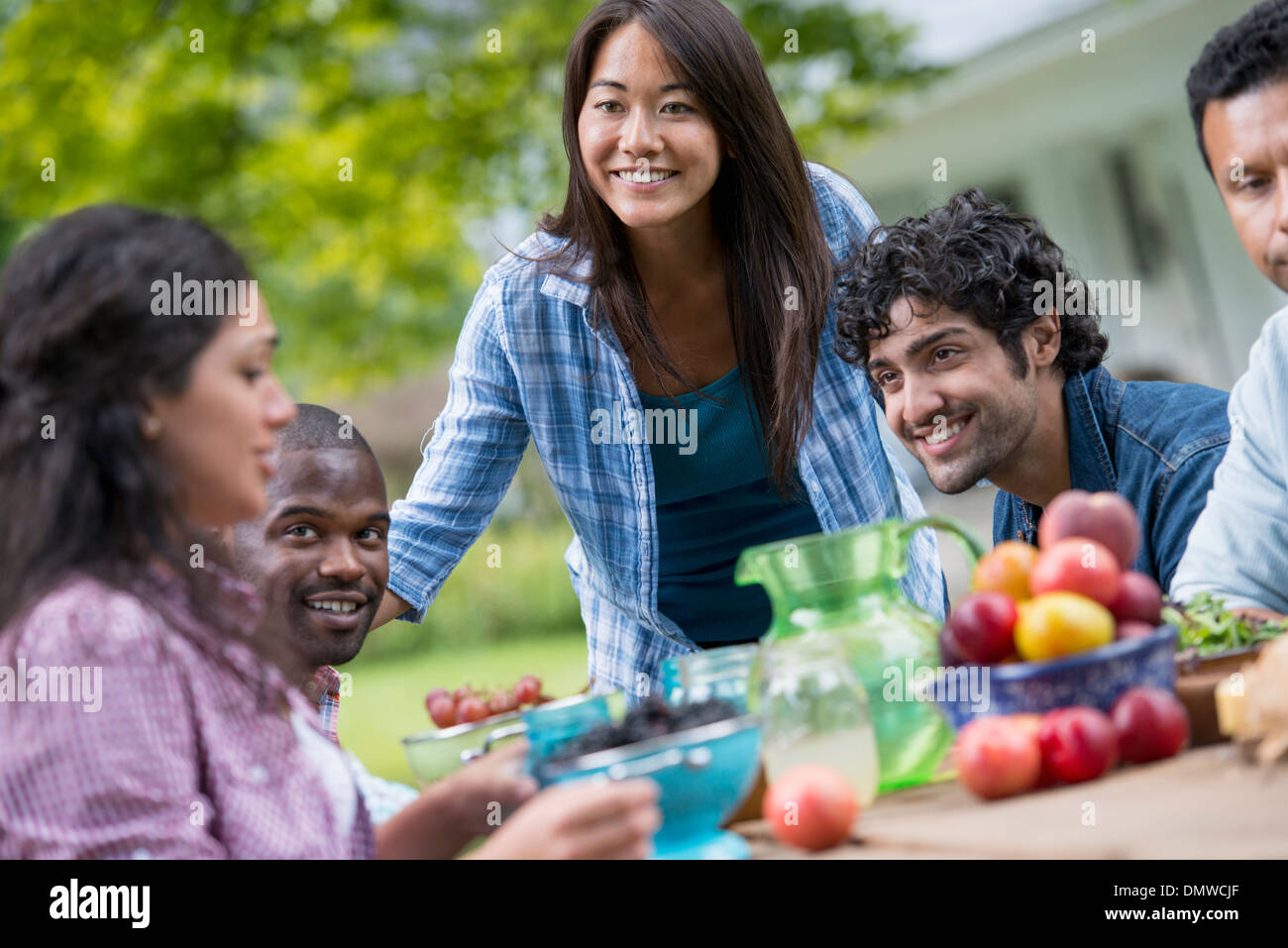 A summer party outdoors. Four people at a table. Stock Photo