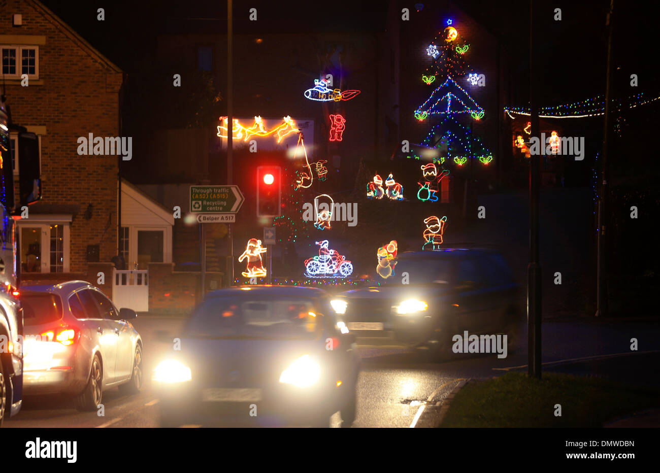 Ashbourne, Derbyshire, UK. 16th December 2013. Driving home for Christmas, sitting on his motorbike, Santa helps to brighten what could be Britain's most festive junction. A number of homes above the traffic lights at the junction of Park Road and Belper Road in Ashbourne, Derbyshire have been decorated with Christmas lights that dwarf the traffic signals below. Credit:  Joanne Roberts/Alamy Live News Stock Photo