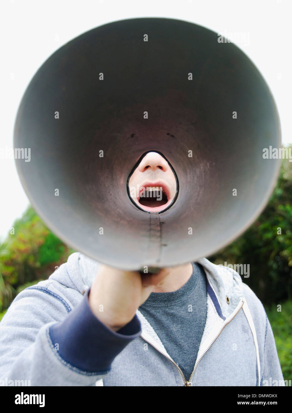 A man using a megaphone in  open air. Stock Photo