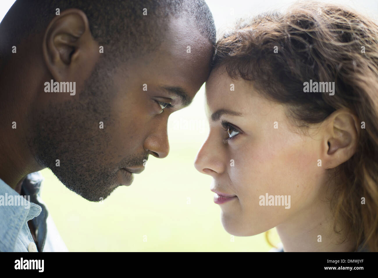 A young man and woman a couple. Touching foreheads viewed in profile. Stock Photo