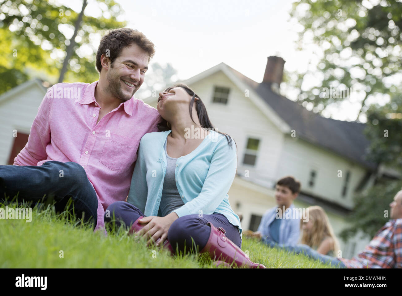 A couple sitting on  grass at a summer party. Stock Photo