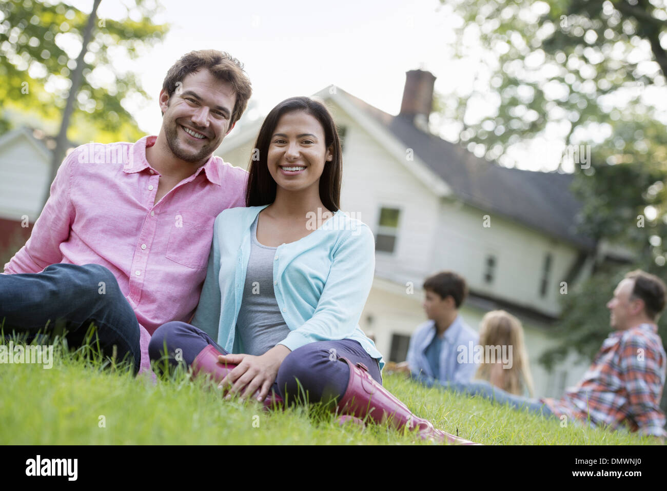 A couple sitting grass at a summer party. Stock Photo