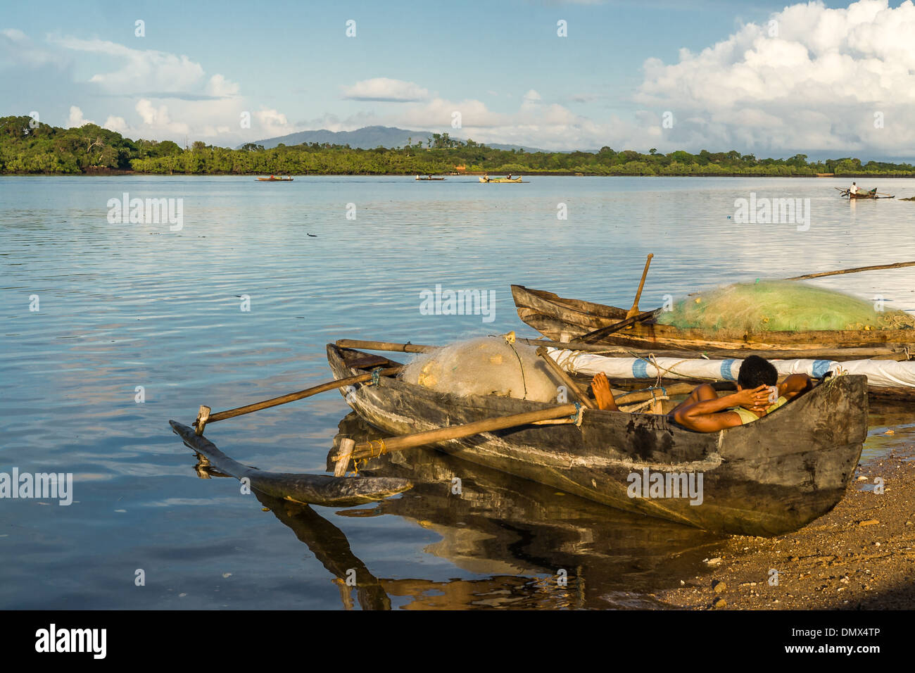 Malagasy people waiting in an outrigger canoe Stock Photo