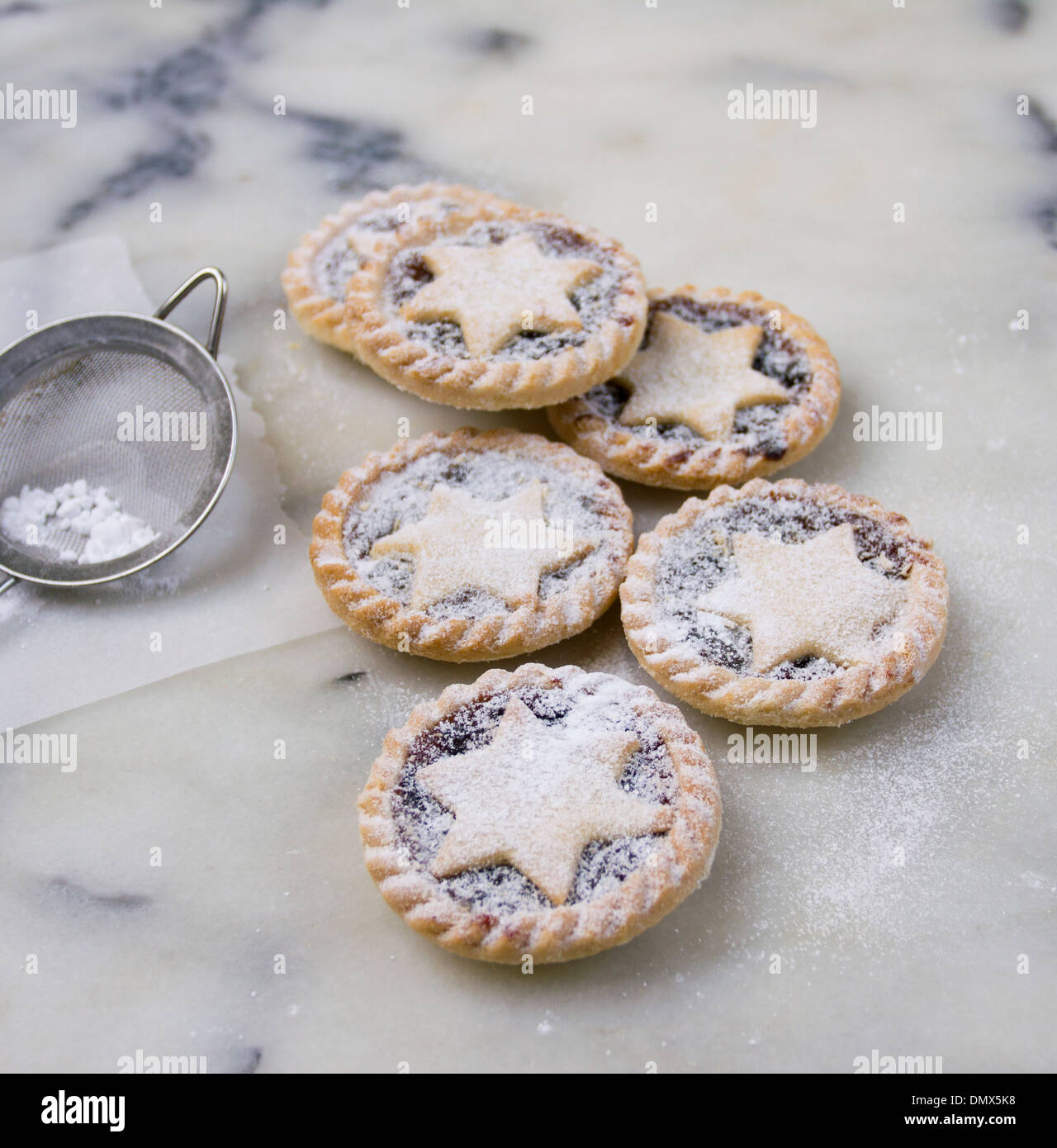 Home made icing sugar dusted mince pies on a grey marble surface Stock ...