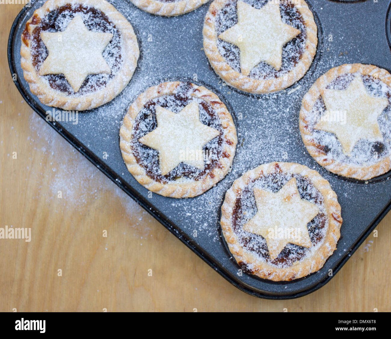 Homemade icing sugar dusted mince pies in baking tray Stock Photo