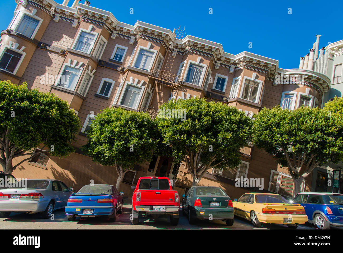 Tilted view of a typical steep street with old apartment buildings and parked cars, San Francisco, California, USA Stock Photo