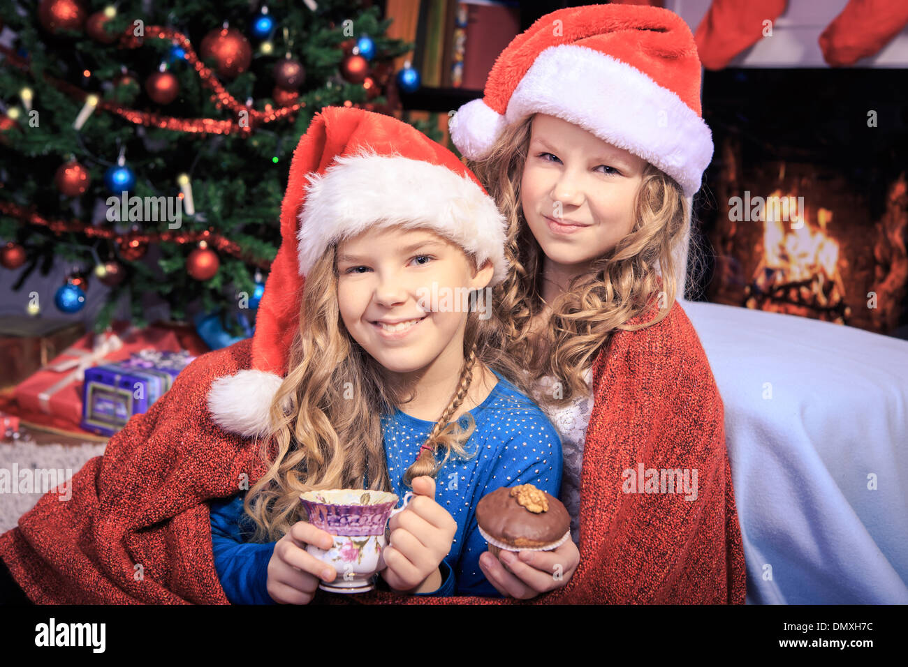 two sisters drinking tea with xmas cookies at home Stock Photo