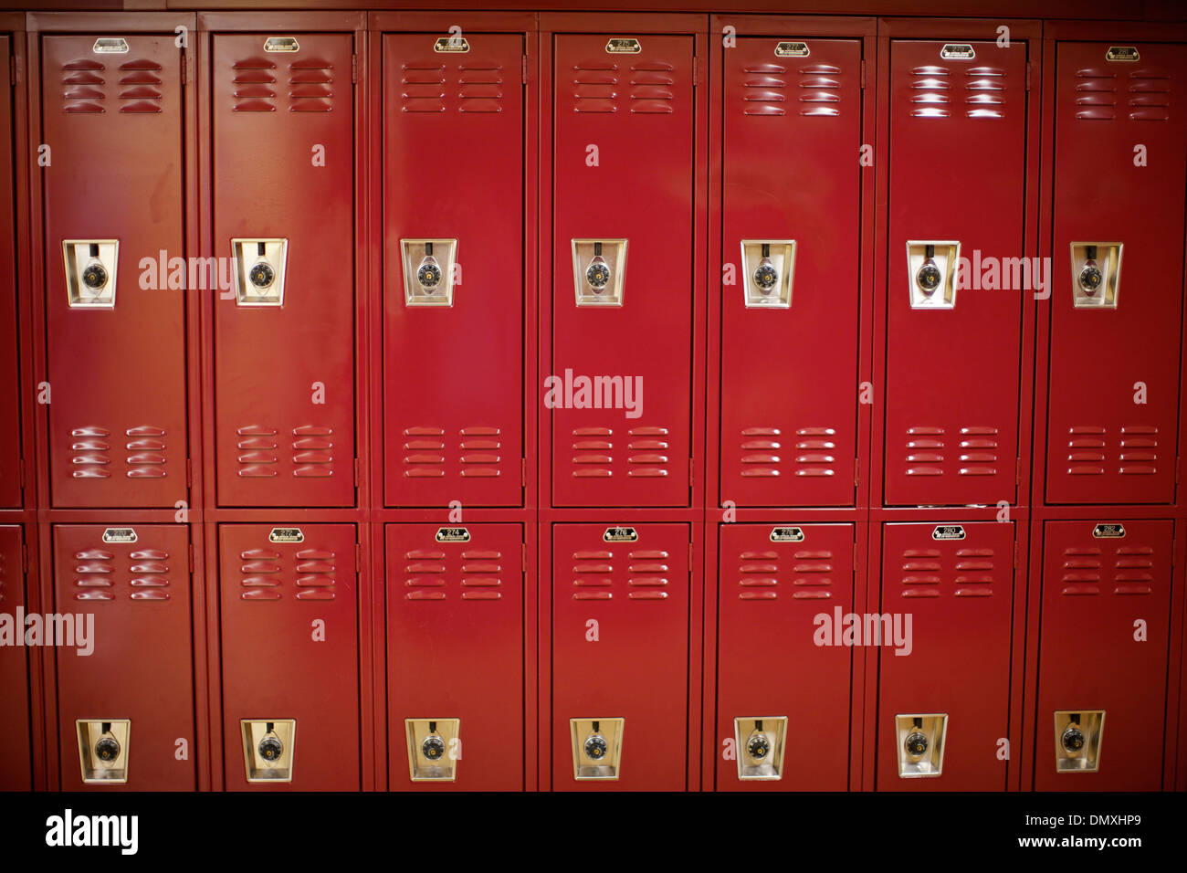 A wall of red lockers in an inner city middle school. Stock Photo