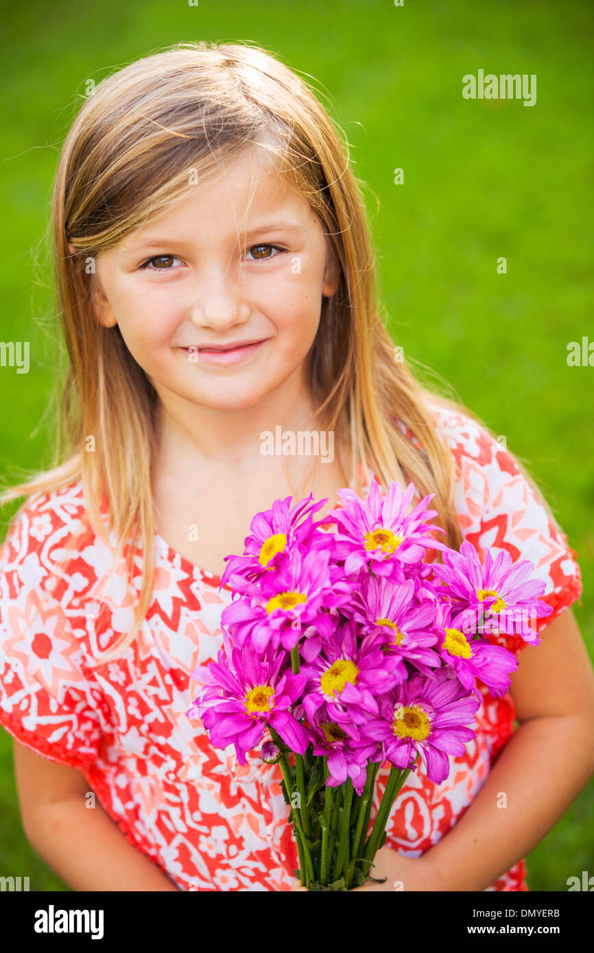 Portrait of a smiling cute little girl with flowers Stock Photo - Alamy
