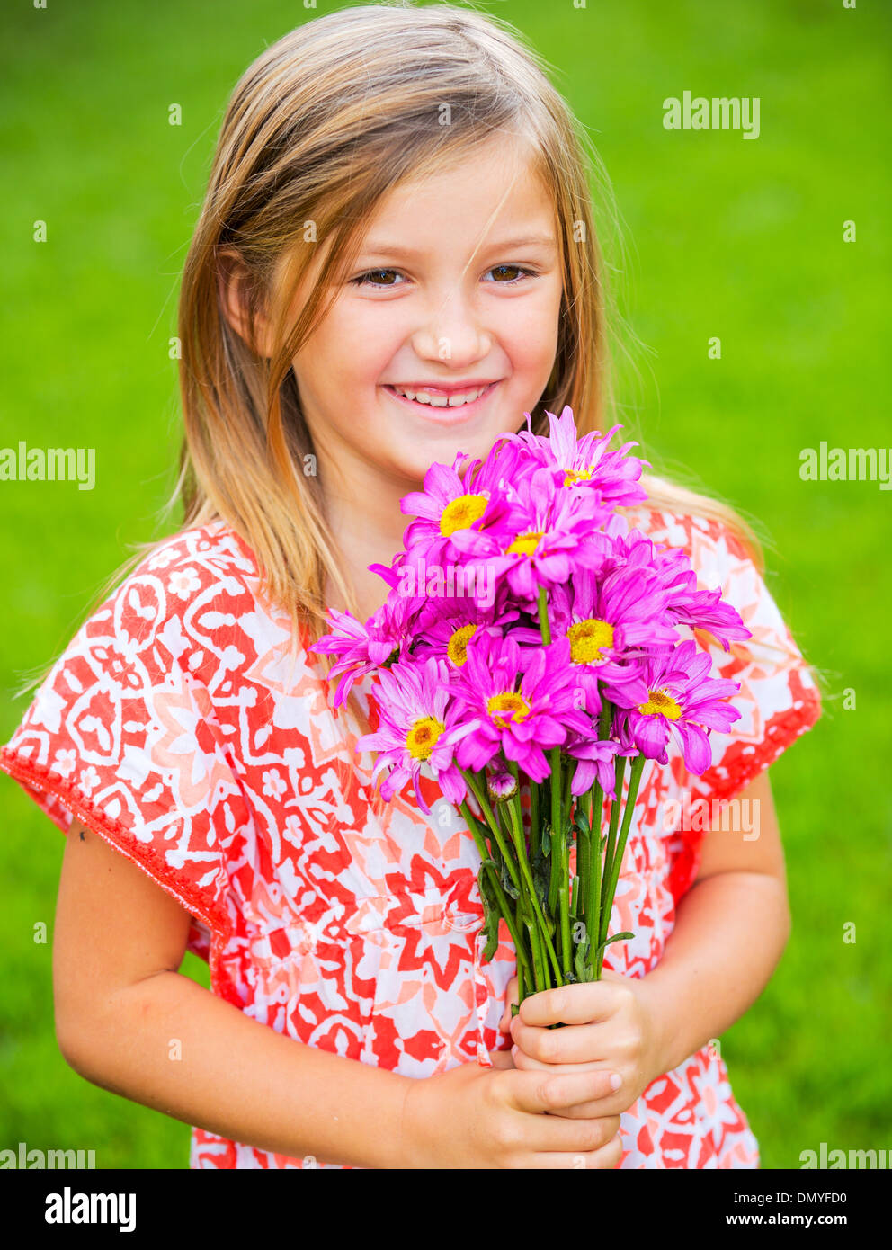 Portrait of a smiling cute little girl with flowers Stock Photo - Alamy