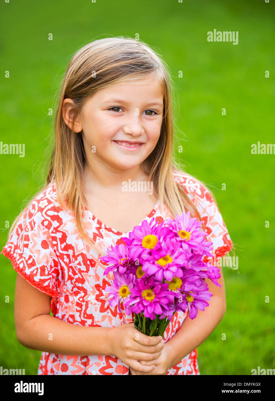 Portrait of a smiling cute little girl with flowers Stock Photo - Alamy