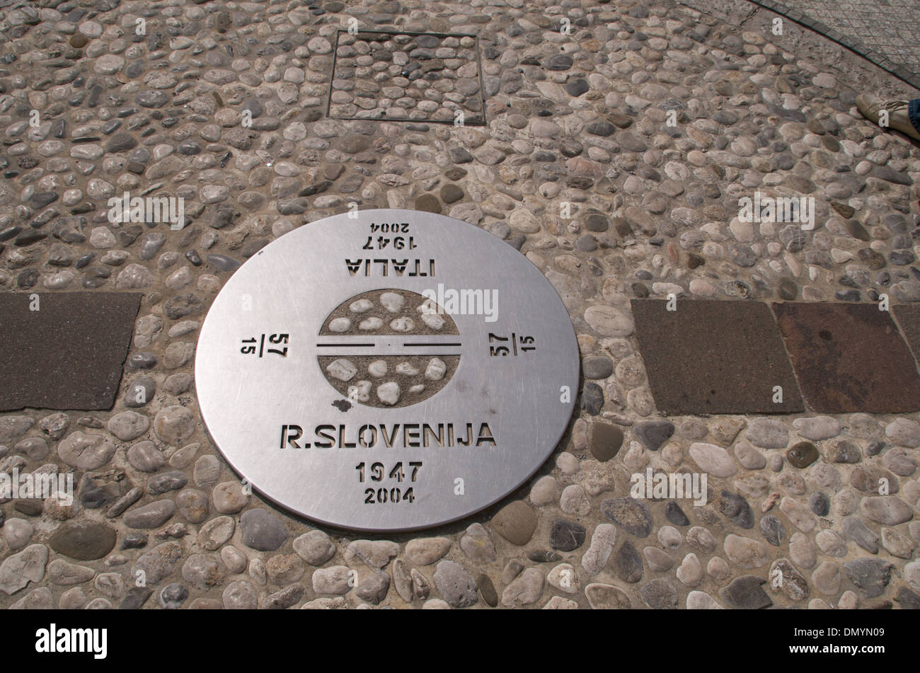 Plaque marking the border between Italy and Slovenia, in the town of Gorizia. The border runs right through the middle. Stock Photo