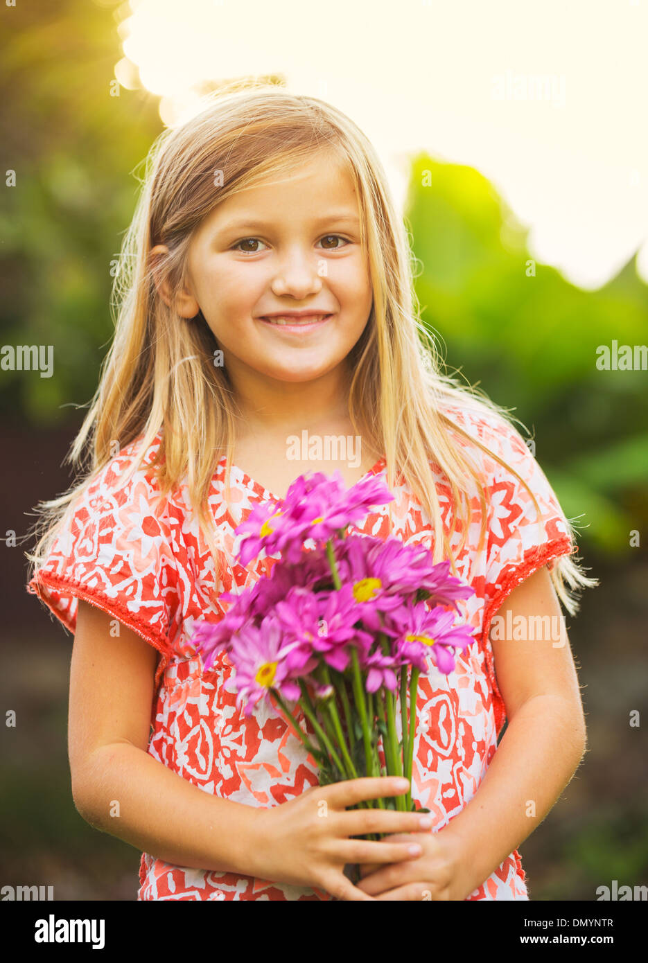 Portrait of a smiling cute little girl with flowers Stock Photo - Alamy