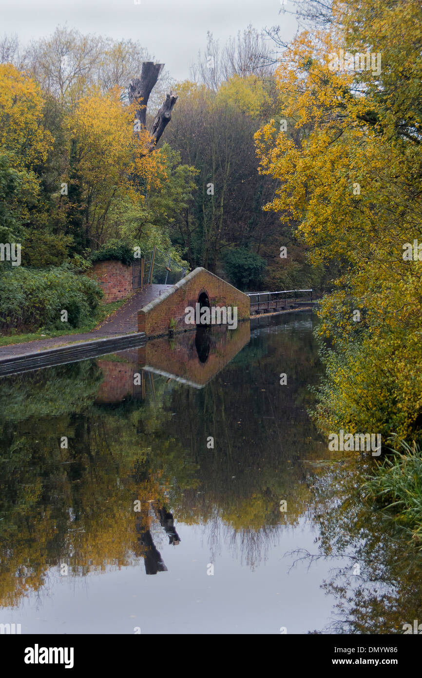 Pedestrian bridge and reflection on towpath of Staffordshire Canal in
