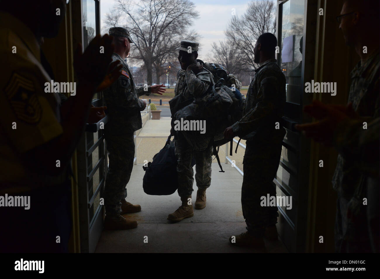 Washington, District of Columbia, US, USA. 17th Dec, 2013. A soldier is welcomed by fellow guardmen at the DC Armory during a homecoming ceremony for nearly 50 soldiers from D.C.'s Army National Guard 372nd Military Police Battalion. The soldiers were returning from a 10-month deployment to Guantanamo Bay, Cuba, in support of Operation Enduring Freedom. Many of the servicemen have deployed at least once previously, and nine work sas police officers while not on military duty. Credit:  Miguel Juarez Lugo/ZUMAPRESS.com/Alamy Live News Stock Photo