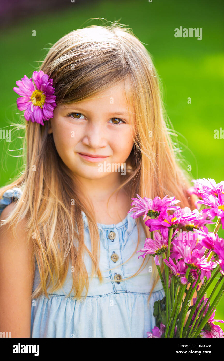 Portrait of a smiling cute little girl with flowers Stock Photo - Alamy
