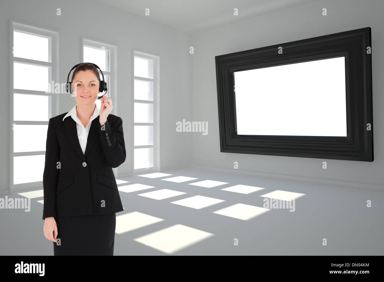 Composite image of good looking woman in suit using headphones and posing Stock Photo