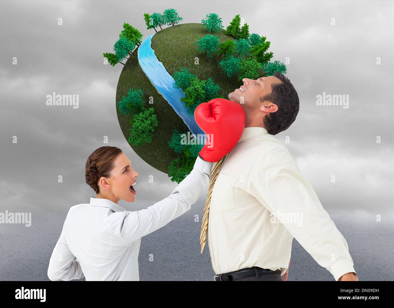 Composite image of businesswoman hitting a businessman with boxing gloves Stock Photo