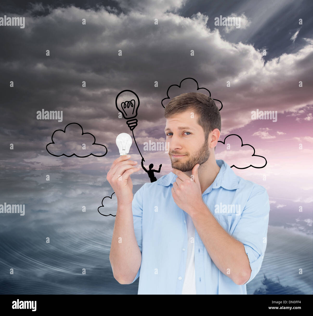 Composite image of handsome model holding a bulb Stock Photo