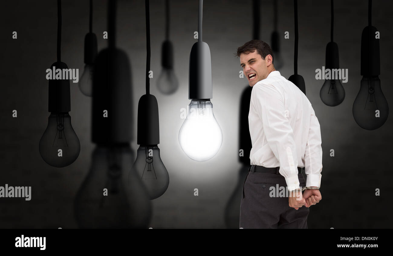 Composite image of rear view of young businessman wearing handcuffs Stock Photo