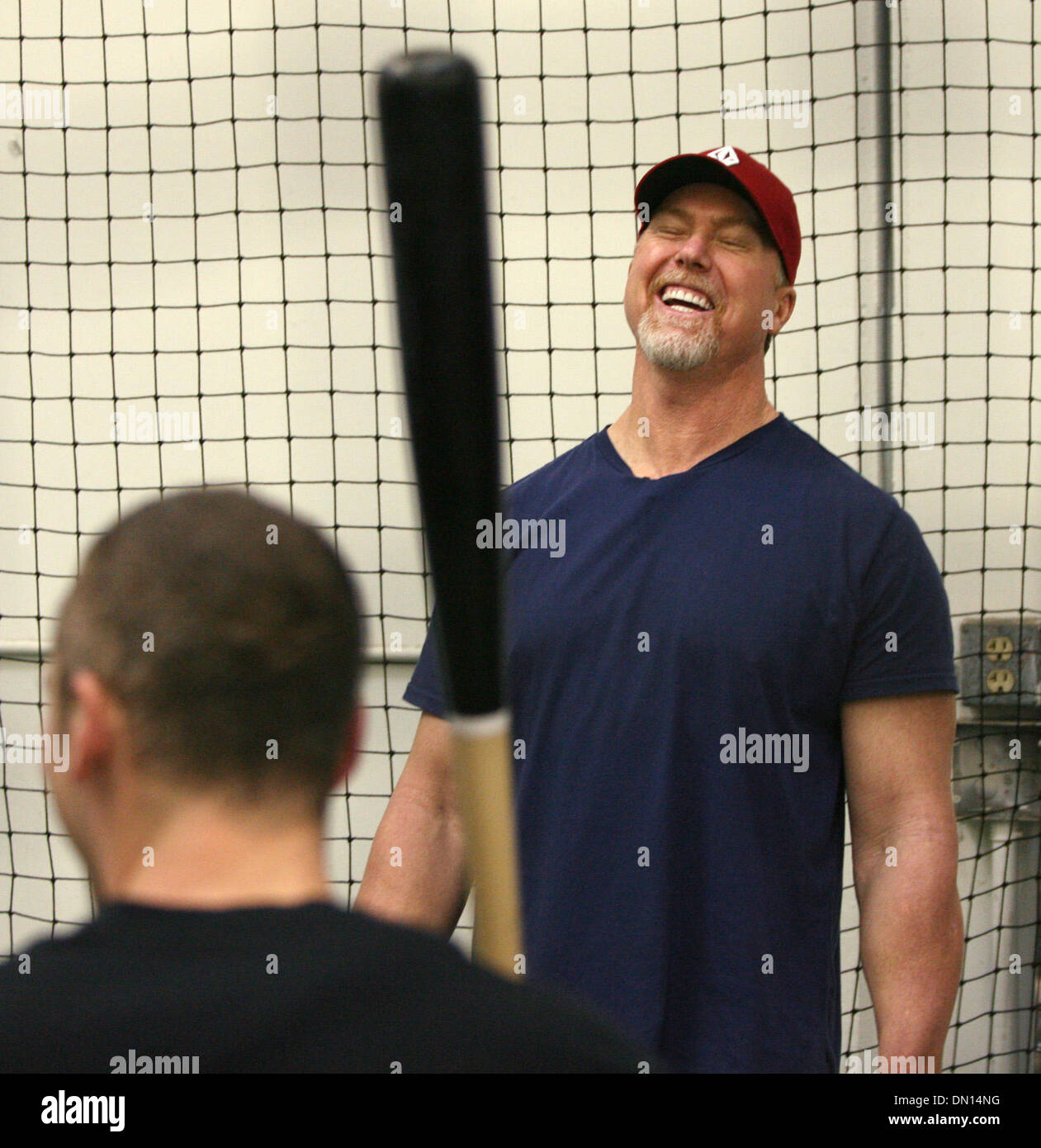 Jan 13, 2010 - Huntington Beach, California, USA - Cardinals hitting instructor MARK MCGWIRE laughs as he works with infielder BRENDAN RYAN during a training session at a local baseball practice facility in Huntington Beach, Calif. The session with the Cardinals infielders was the first McGwire had had since his announcement Monday that he used performance enhancing drugs during hi Stock Photo