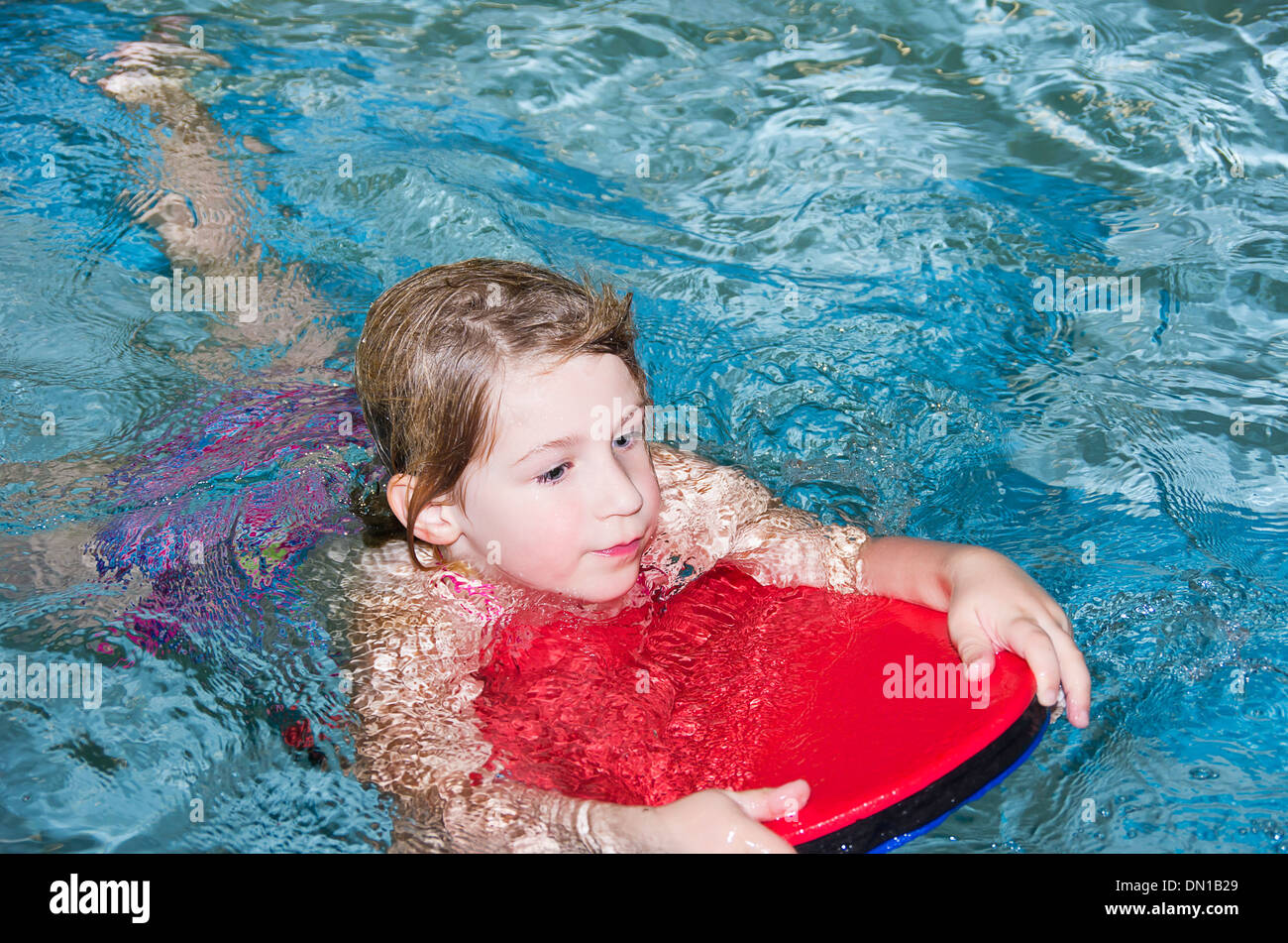Little Girls Swims With Swimming Board Stock Photo