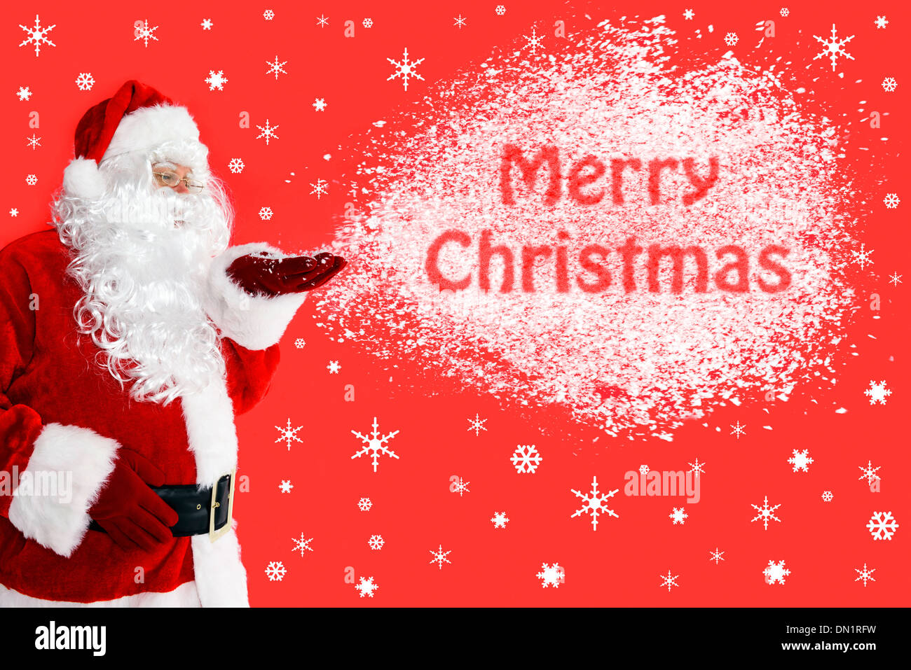 Santa Claus or Father Christmas blowing snow from his hand with the words Merry Christmas in