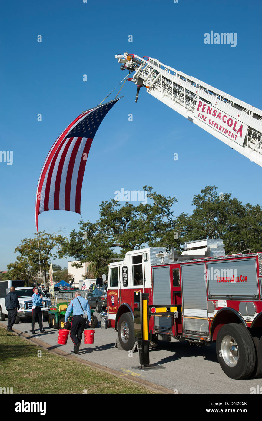 Pensacola Fire Department firemen setting out a large stars and stripes flag on Veterans Day Florida USA Stock Photo