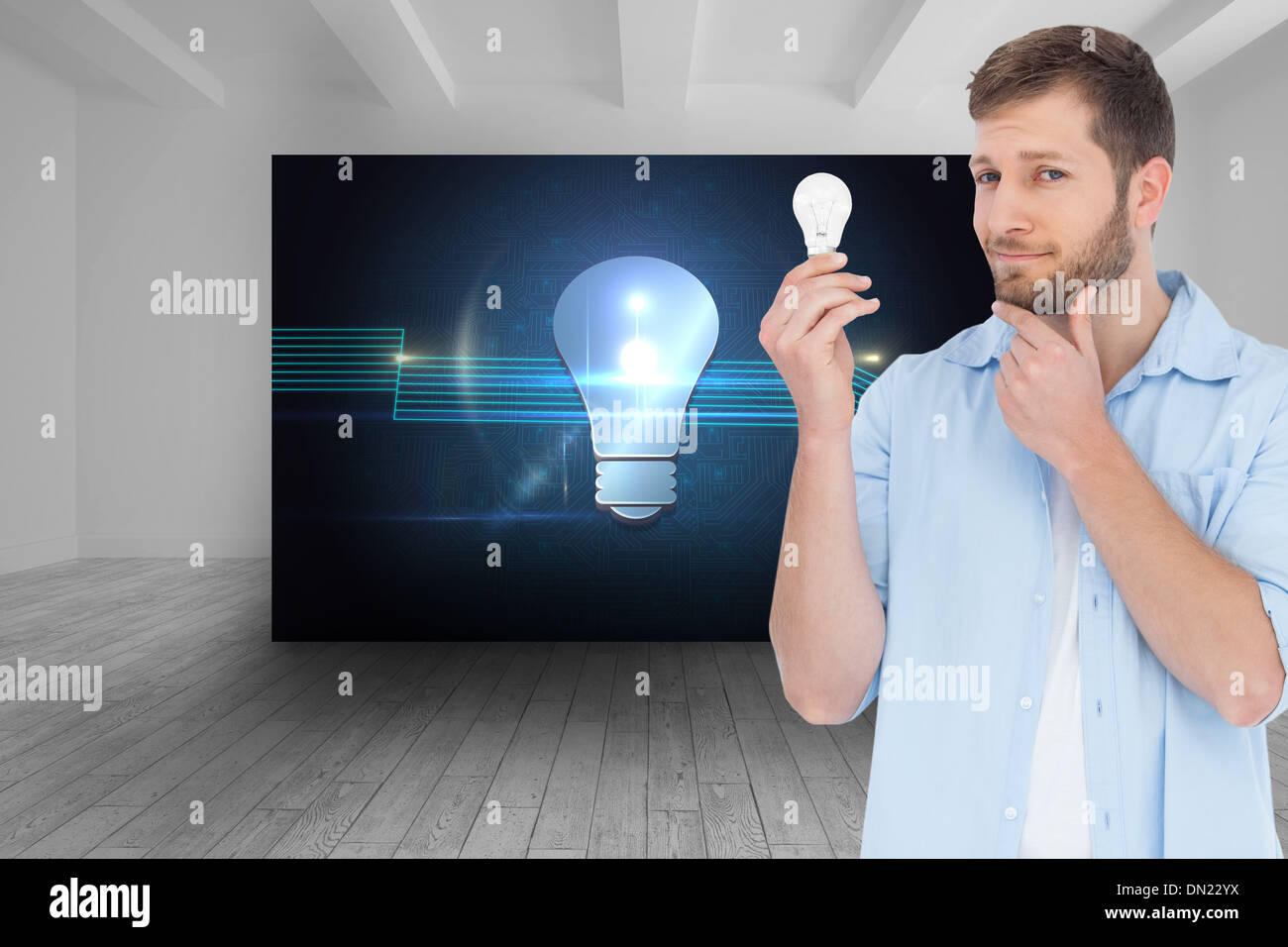 Composite image of handsome model holding a bulb Stock Photo