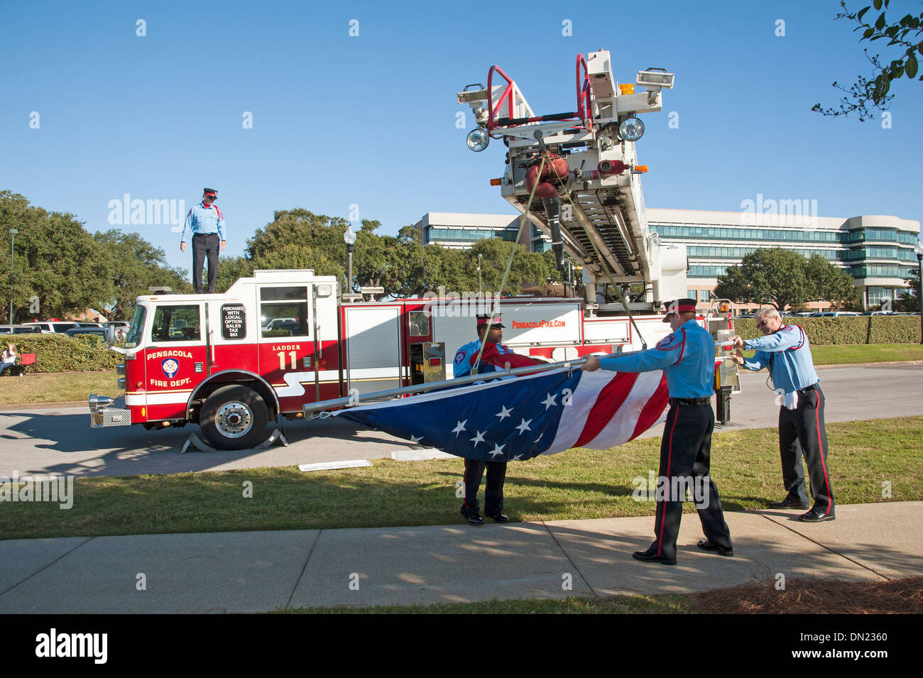 Pensacola Fire Department firemen setting out a large stars and stripes flag on Veterans Day Florida USA Stock Photo