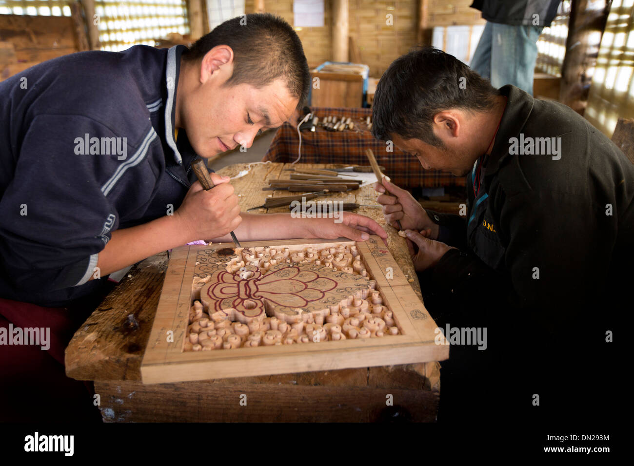 Bhutan, Bumthang Kurjey Lhakang monastery, craftsmen carving wooden panel Stock Photo