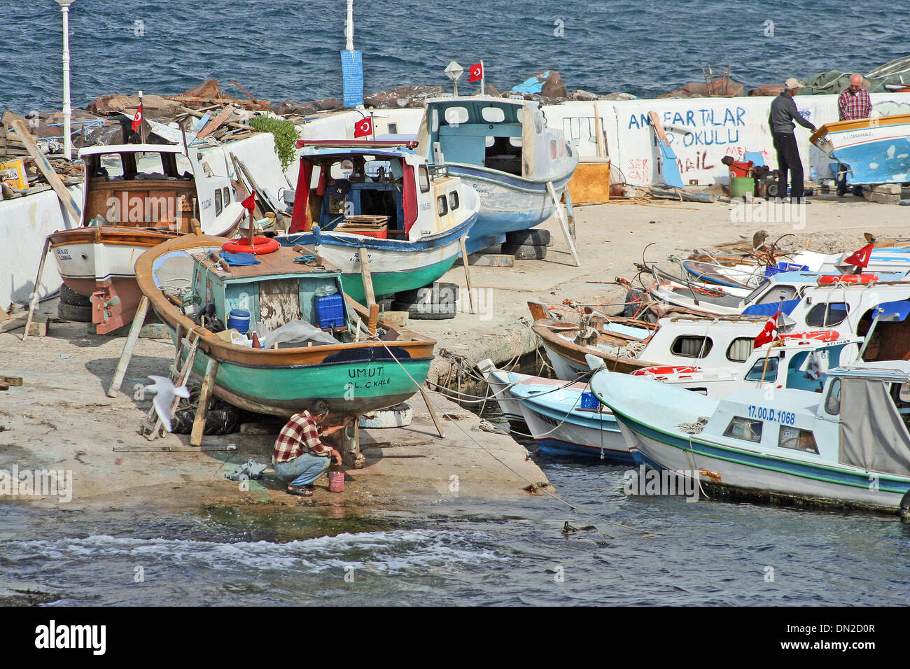 Turkish fishermen work on their boats in the harbour at Canakkale, on the Asian shore of the Dardanelles. Stock Photo