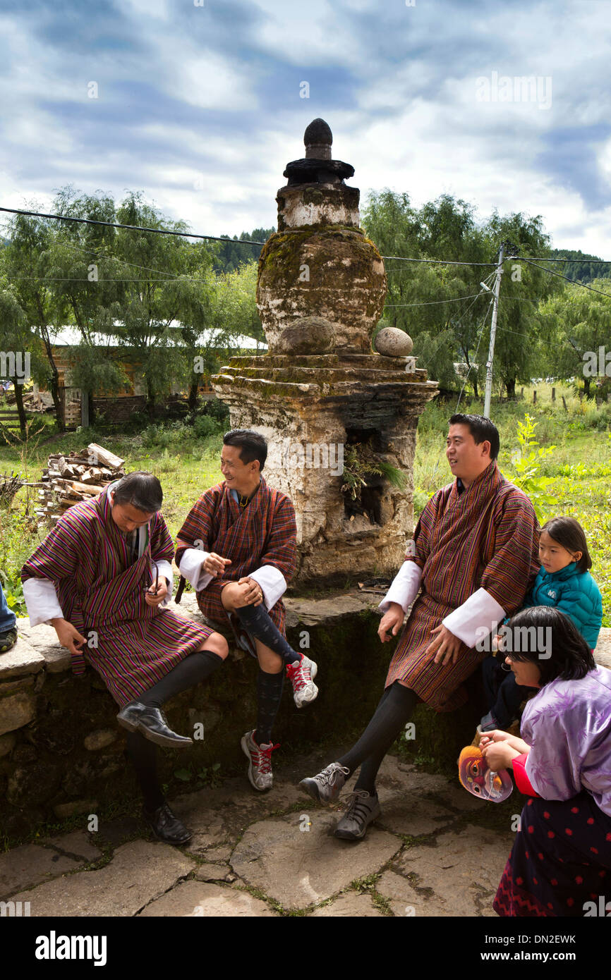 Bhutan, Bumthang Thangbi Mani Lhakang monastery, men in Gho sat by incense burner Stock Photo