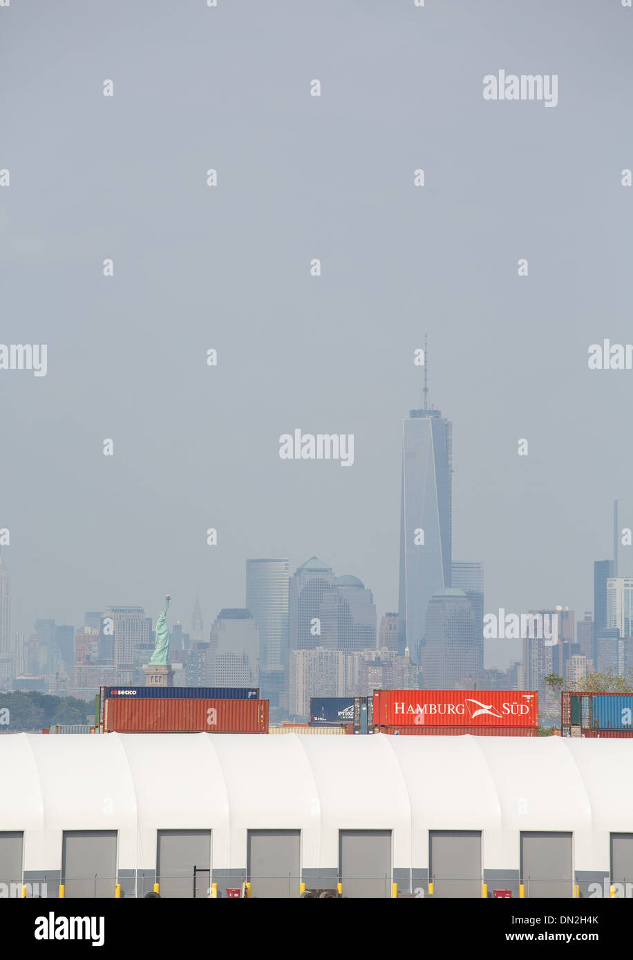 A freight terminal in New York harbor with the Statue of Liberty and skyline in the background Stock Photo