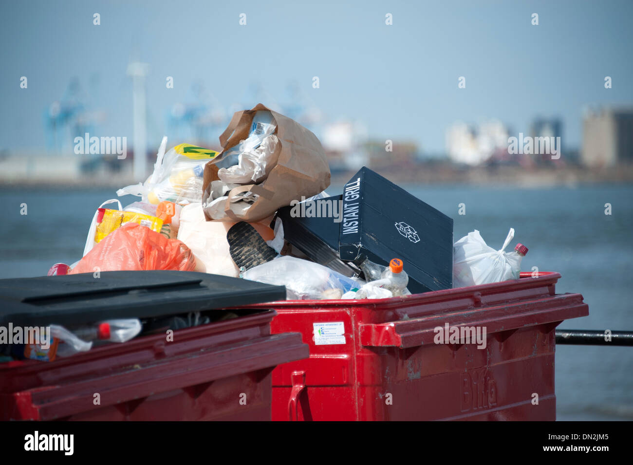 Rubbish piled high overflowing commercial bin Stock Photo