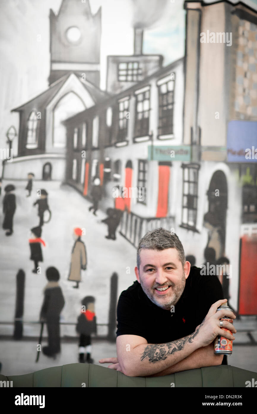 Manchester, UK. 16th December 2013. Hulme artist Tony Brady (Kelzo) now living in Salford has used spray paint to recreate a lowry matchstick-men scene for Craftbrew (cafe) in Salford Quays, a new cafe opposite the Lowry Theatre. The view shows a Lowry style street and Media City home of the BBC in the north of England Credit:  Mark Waugh/Alamy Live News Stock Photo