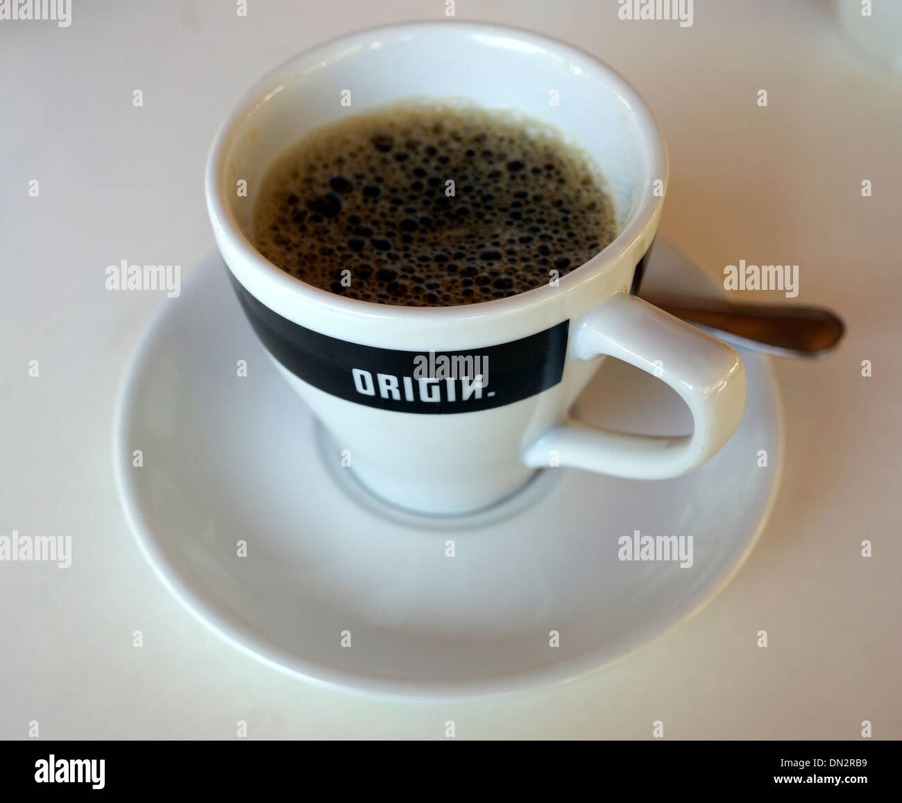 Freshly poured cup of black coffee with logo on side of cup. Stock Photo