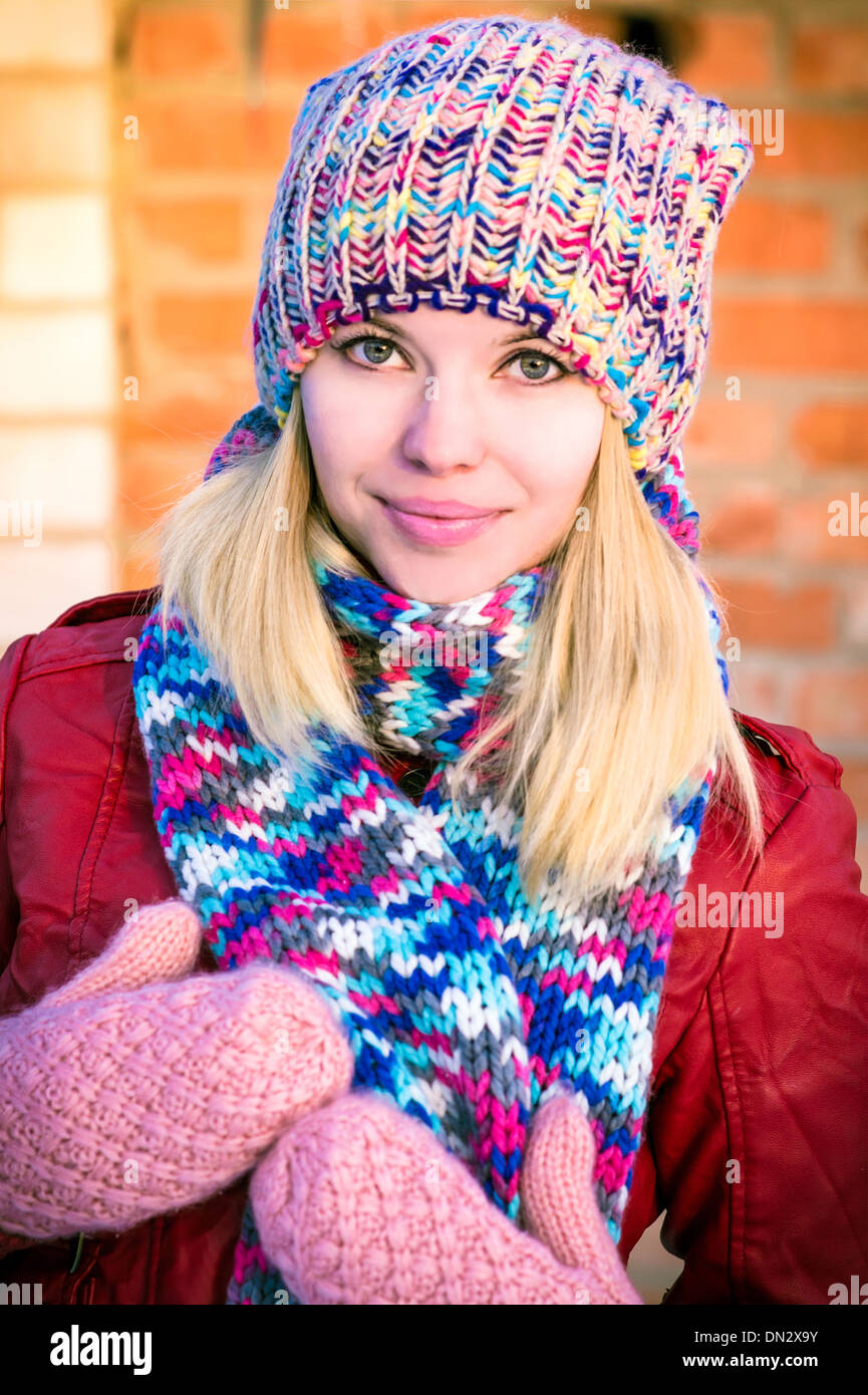 Young Woman Beautiful happy smiling Face Winter time wearing knitted hat and scarf with mittens Lifestyle urban fashion style Stock Photo