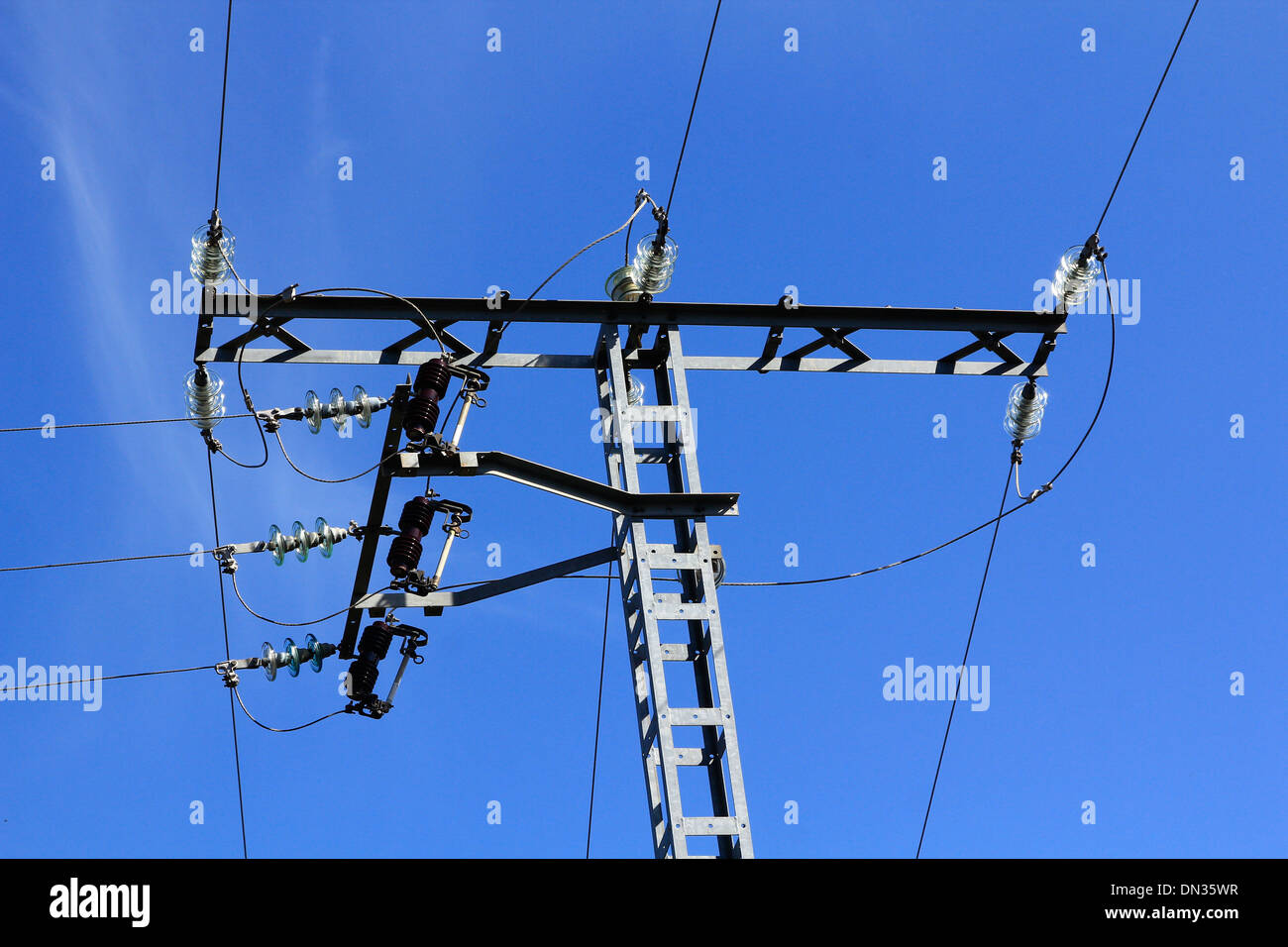 High voltage tower with blue sky behind Stock Photo - Alamy