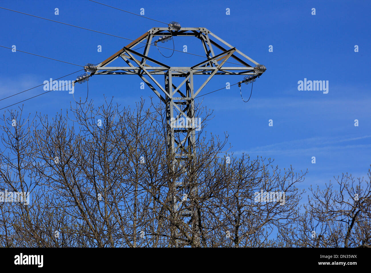 High voltage tower with blue sky behind Stock Photo - Alamy