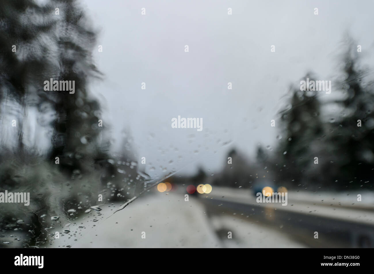 Car drives along snow covered trunk road in daylight in winter conditions in UK Stock Photo